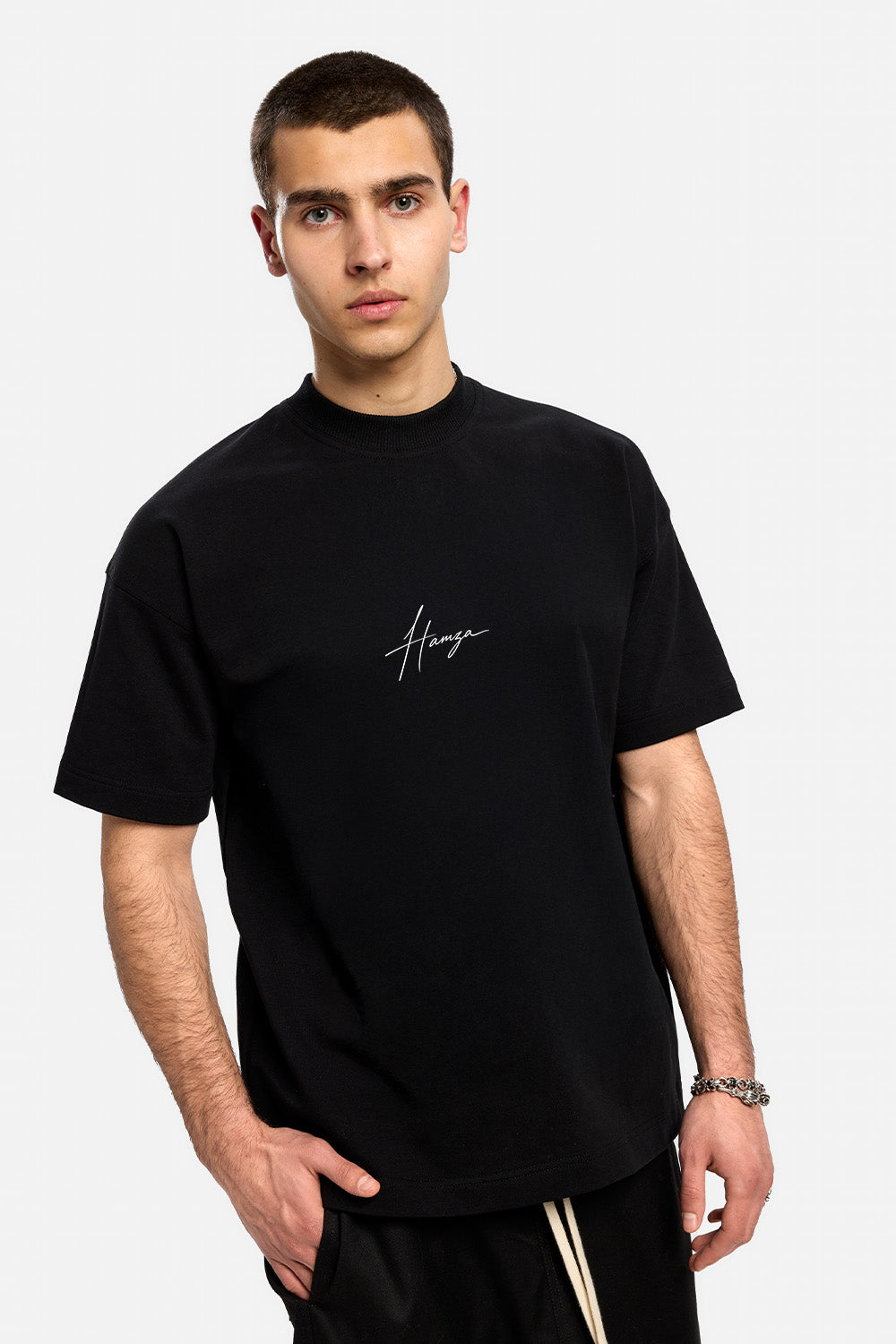 Vedere frontală din unghi a unui model purtând tricoul oversized negru They Will Ignore You pentru bărbați