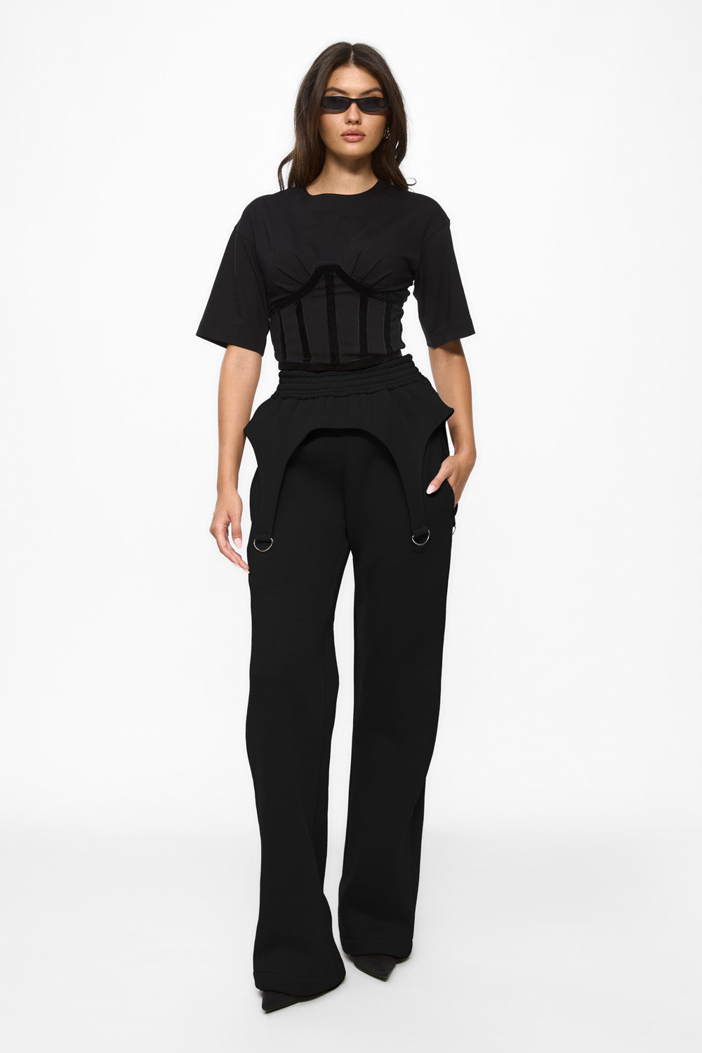 Woman wearing a black outfit with unique design elements on a white background