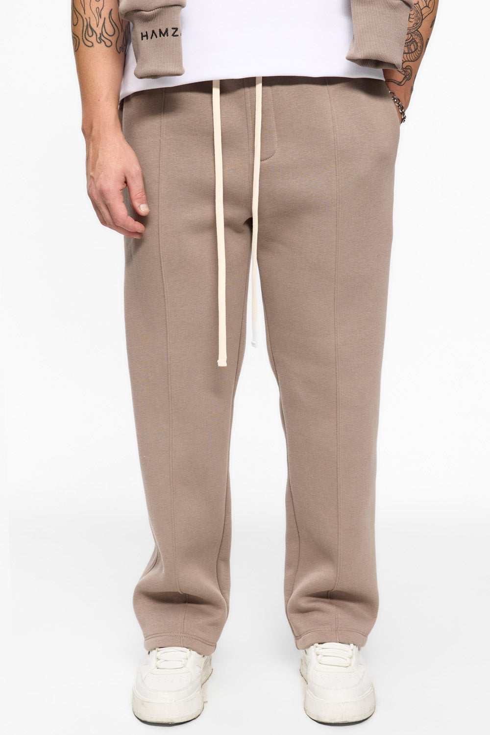 Beige pants worn by a person on a white background