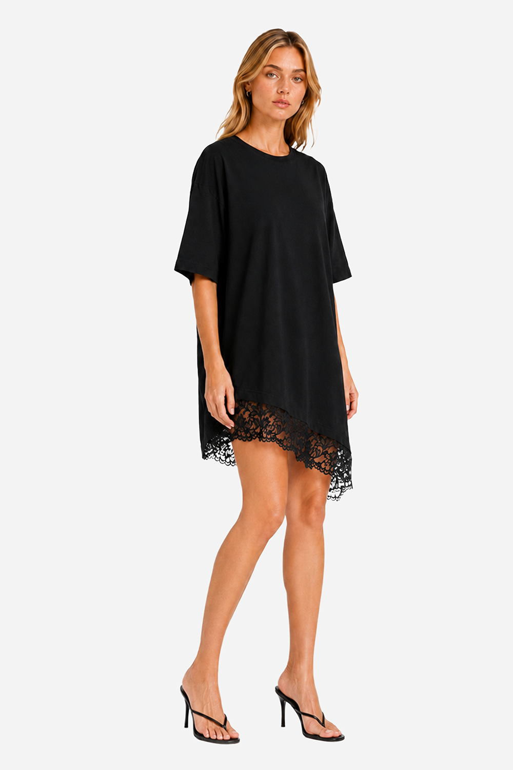 Rochie oversized damă neagră din vâscoză cu tiv asimetric decorat cu dantelă, purtată de un model feminin, vedere laterală