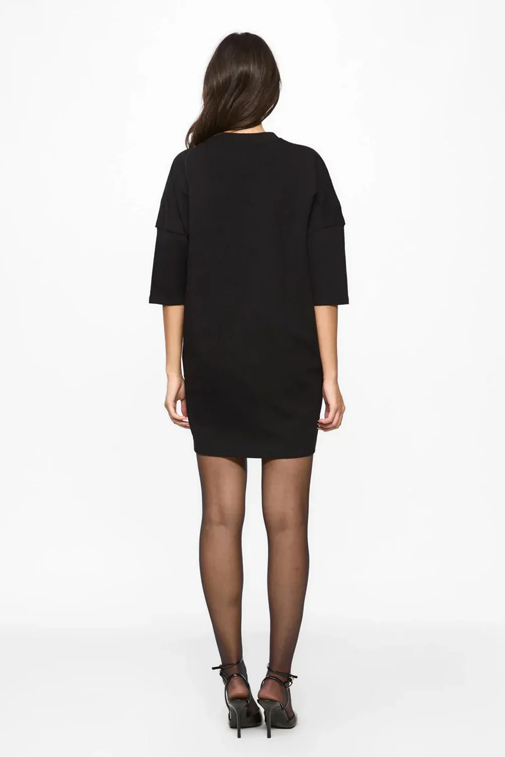 Rochie mini oversized damă neagră din bumbac organic cu imprimeu frontal, purtată de un model feminin, vedere din spate